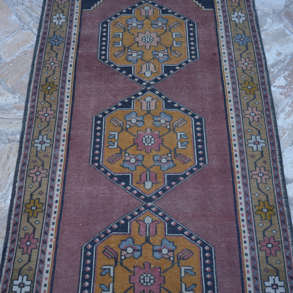 Close-up of the pale purple vintage turkish runner rug showing traditional details, hand-knotted weave, wool and cotton and low pile.