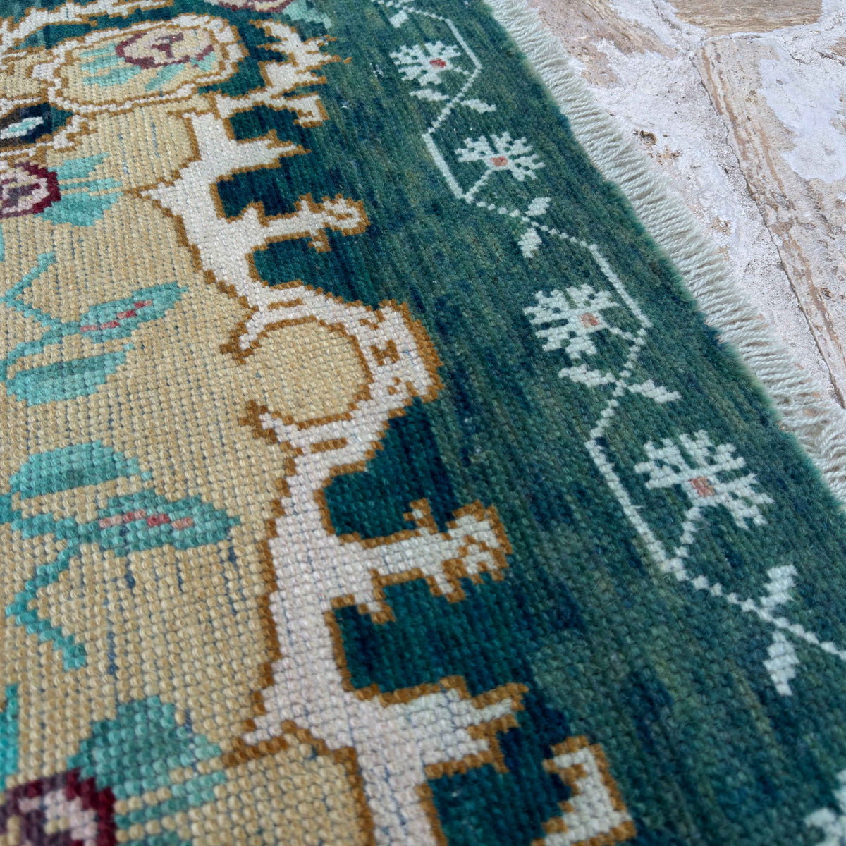 Close-up of the pale green vintage Turkish wool carpet showing traditional details, hand-knotted weave, wool and cotton and low pile.