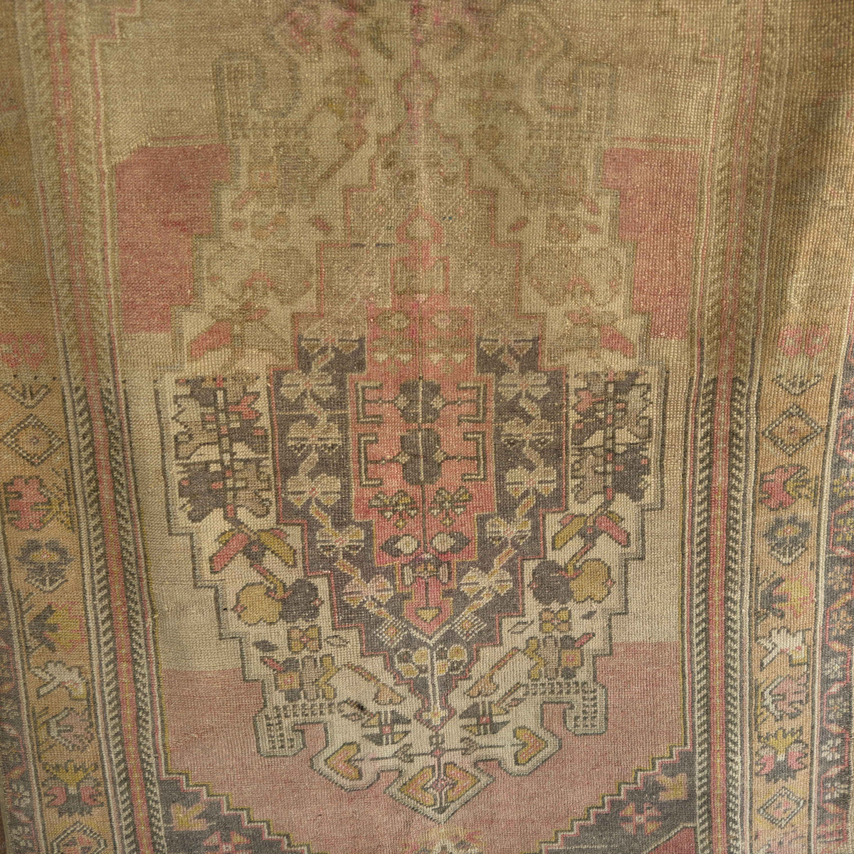 Pink 4' x 6' vintage Turkish wool rug in wool and cotton, shown on the floor.