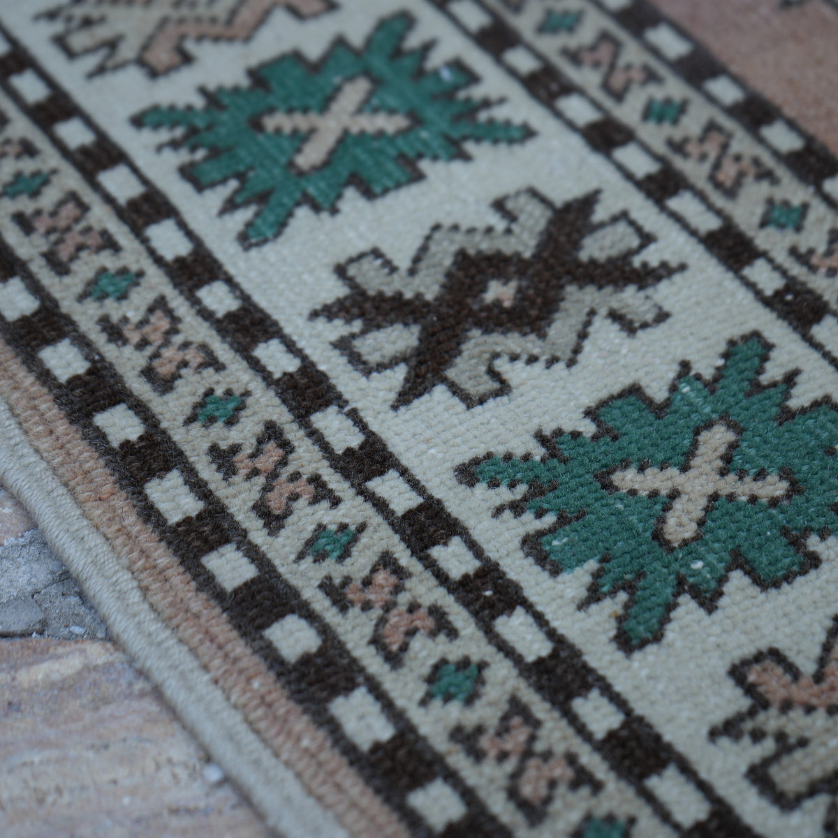 Beige 5' x 7' vintage Turkish wool rug in wool, shown on the floor.
