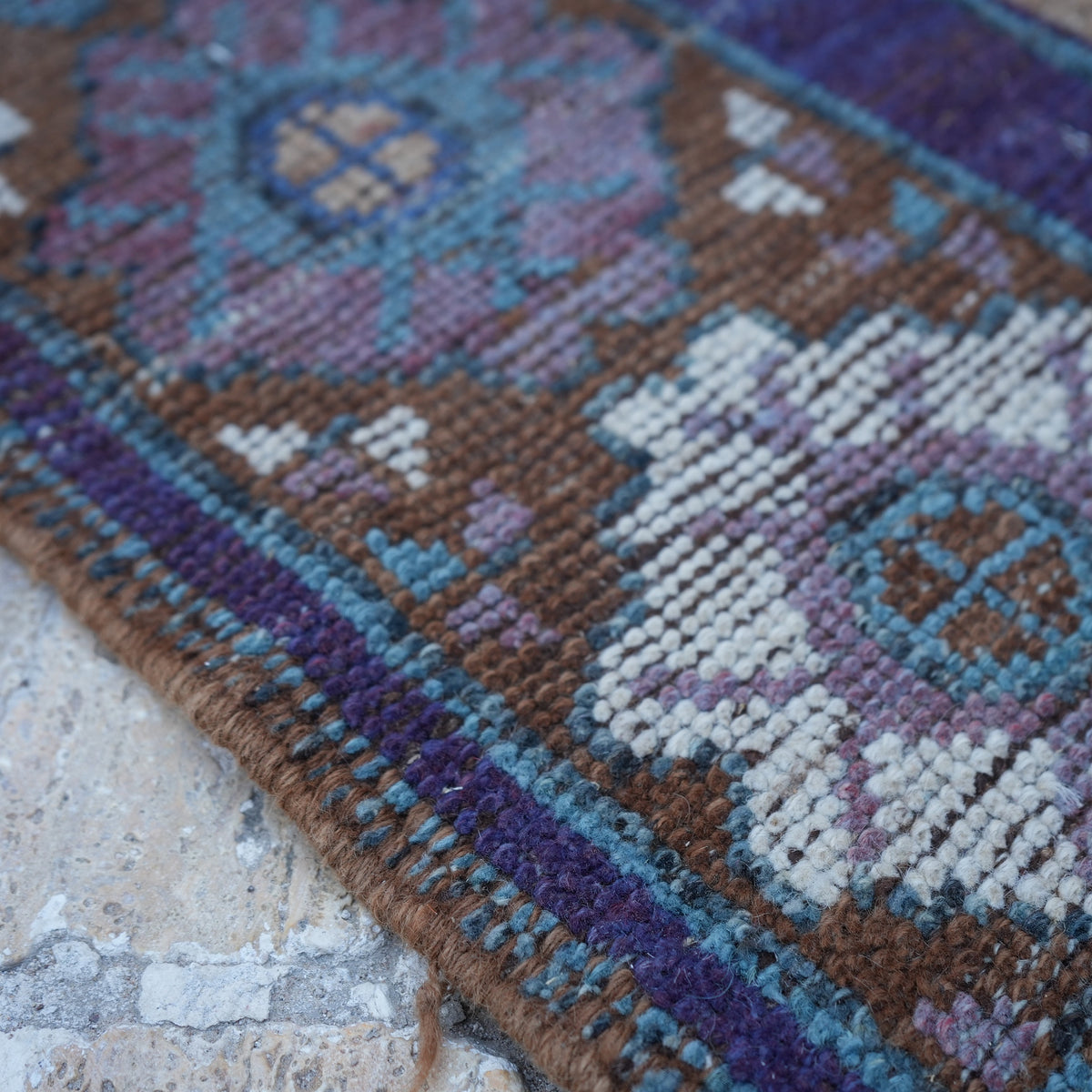Purple 5' x 9' vintage Turkish wool rug in wool, shown on the floor.