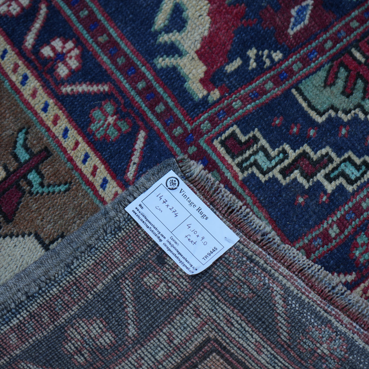 Red 5' x 9' vintage Turkish wool rug from the 1970s with traditional design.