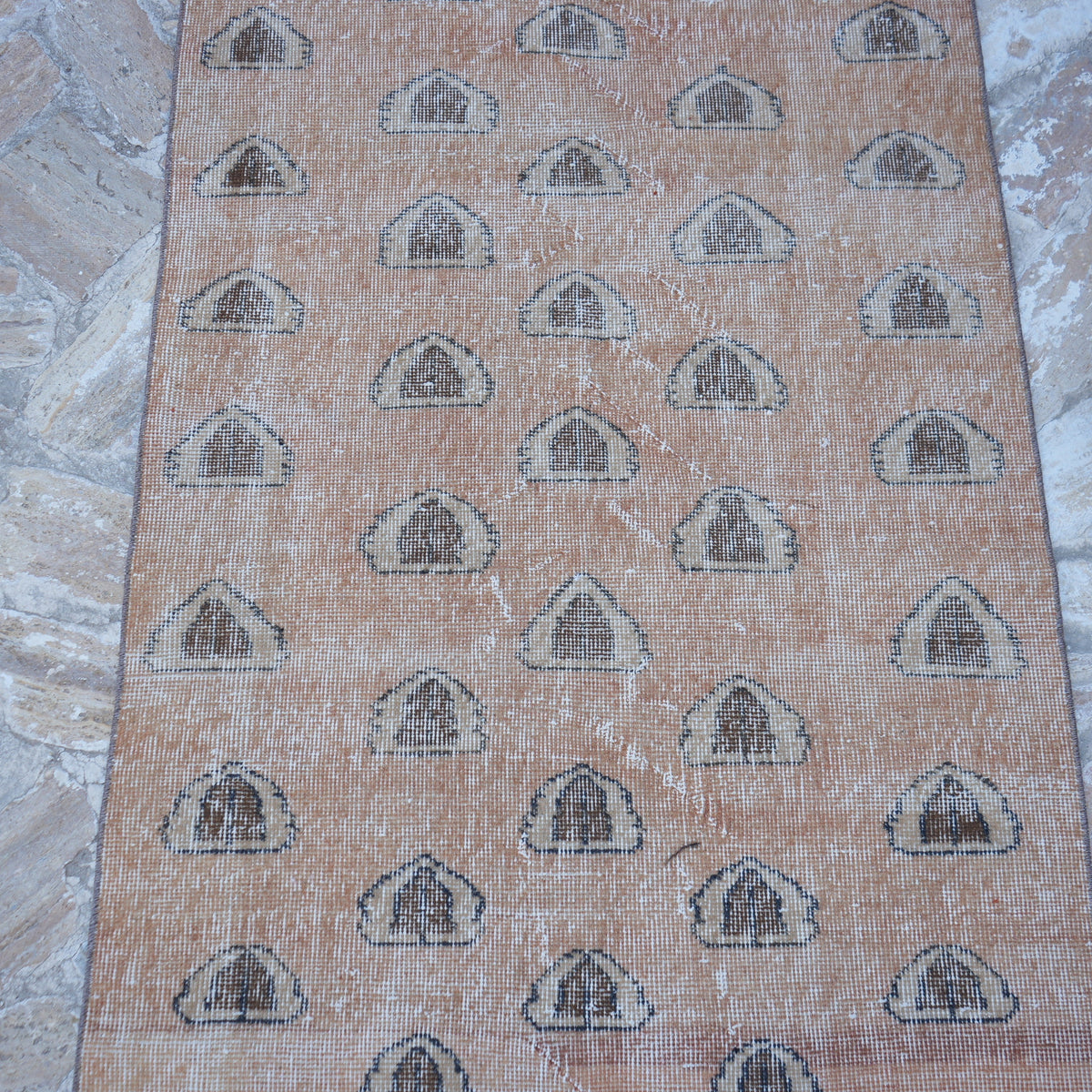 Close-up of the pale orange Turkish art decor rug showing traditional details, hand-knotted weave, wool and cotton and low pile.