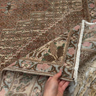 Close-up of the brown authentic vintage persian rug showing neutral details, hand-knotted weave, wool and cotton and low pile.