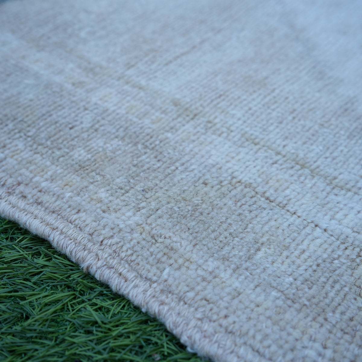 Beige 2' x 4' Turkish authentic vintage rug in wool, shown on the floor.