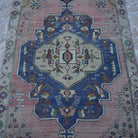 Close-up of the pink Turkish authentic vintage rug showing traditional details, hand-knotted weave, wool and cotton and low pile.