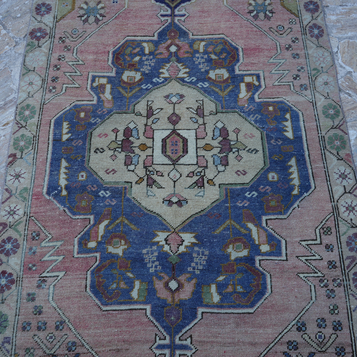 Close-up of the pink Turkish authentic vintage rug showing traditional details, hand-knotted weave, wool and cotton and low pile.
