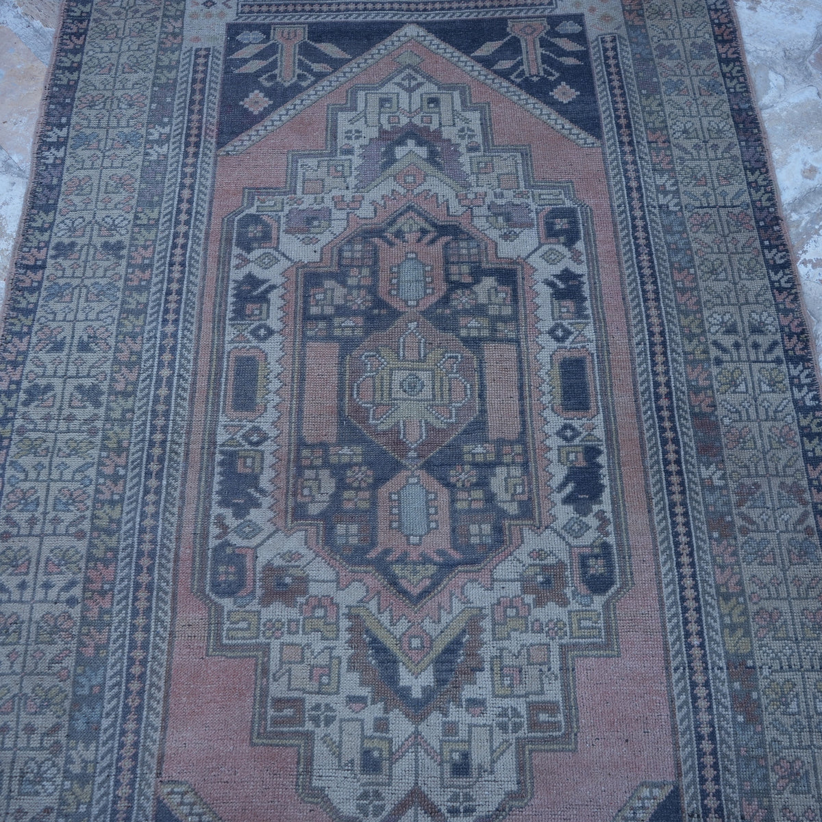 Close-up of the pink Turkish authentic vintage rug showing traditional details, hand-knotted weave, wool and low pile.