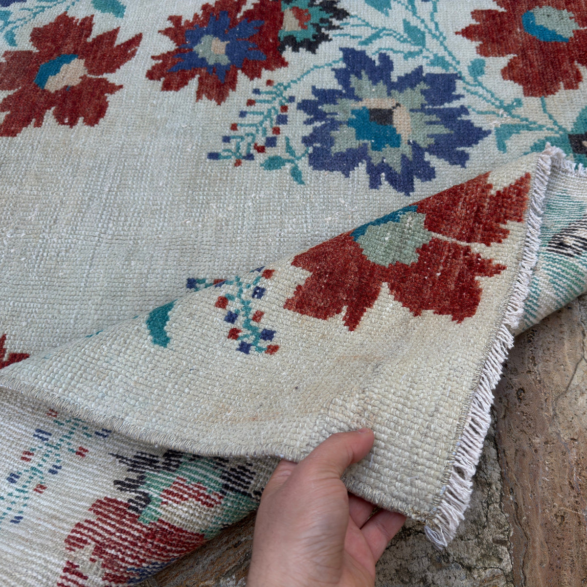 Close-up of the beige Turkish authentic vintage runner rug showing floral details, hand-knotted weave, wool and cotton and low pile.