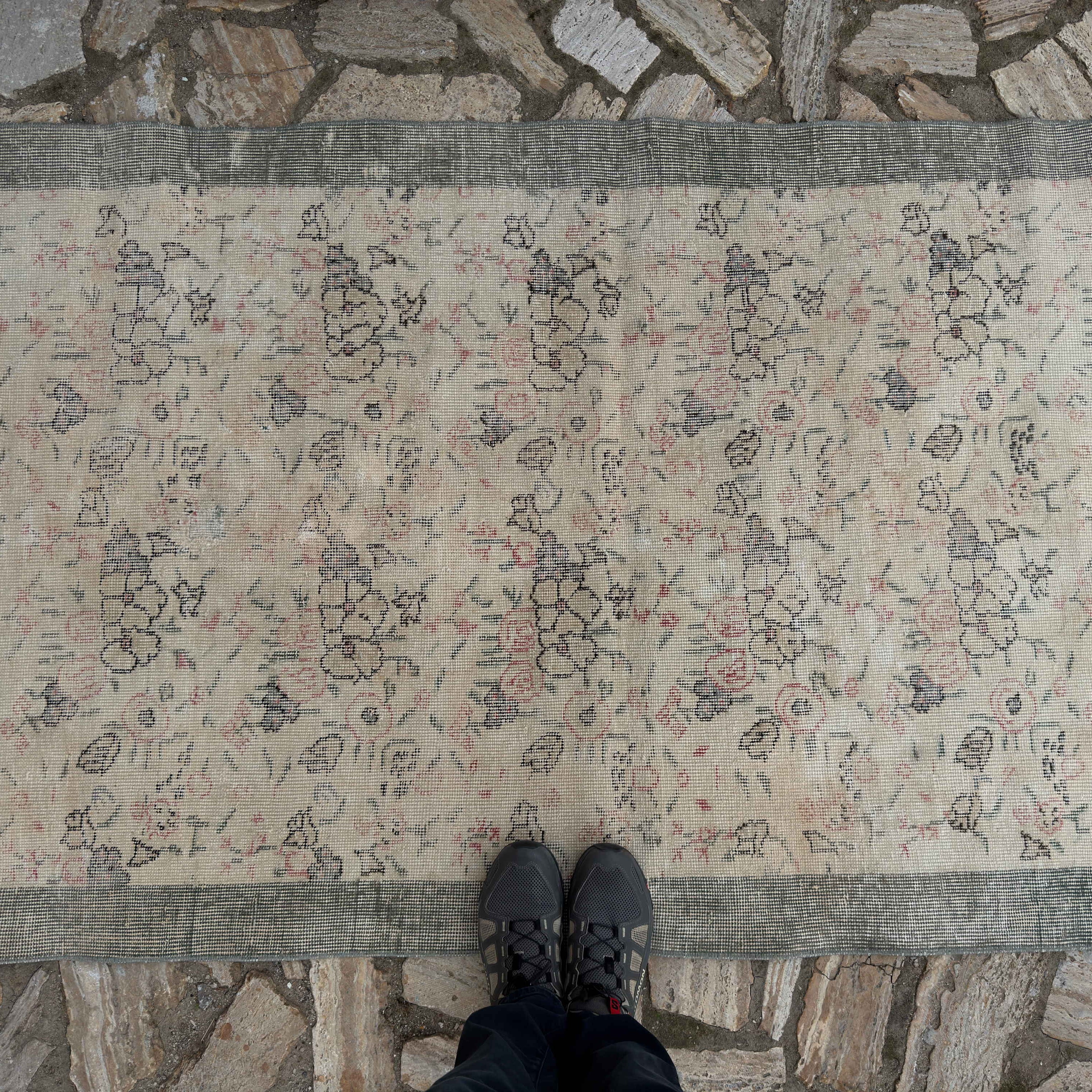 1970s pale green Turkish distressed floral rug with floral design, hand-knotted weave and low pile.
