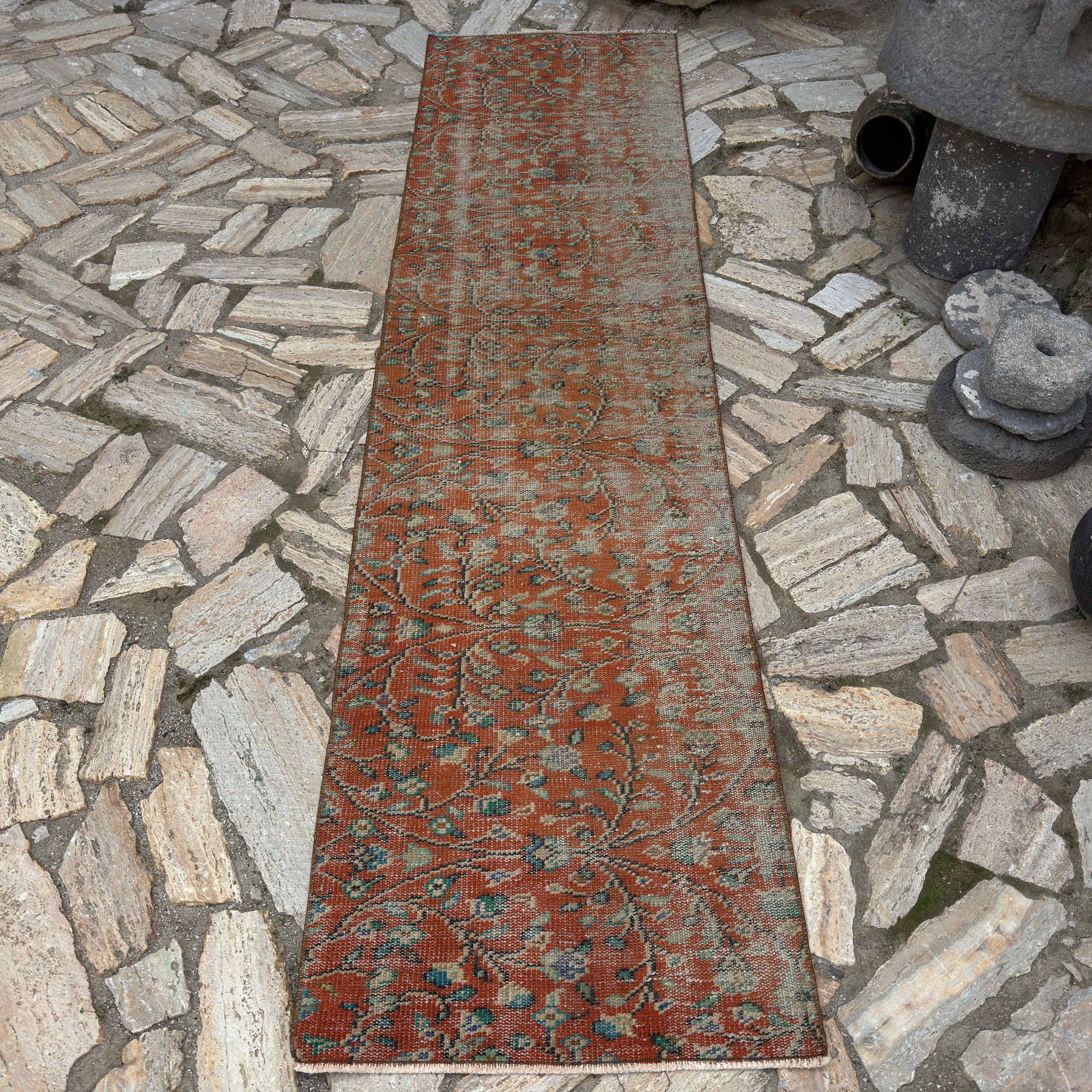 Red 2' x 9' Turkish distressed floral runner rug in wool and cotton, shown on the floor.