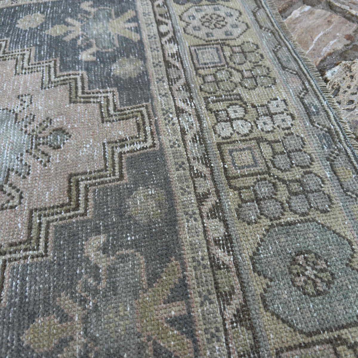 Close-up of the beige Turkish distressed rug showing traditional details, hand-knotted weave, wool and cotton and low pile.