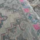 Close-up of the pink Turkish distressed rug showing traditional details, hand-knotted weave, wool and cotton and low pile.