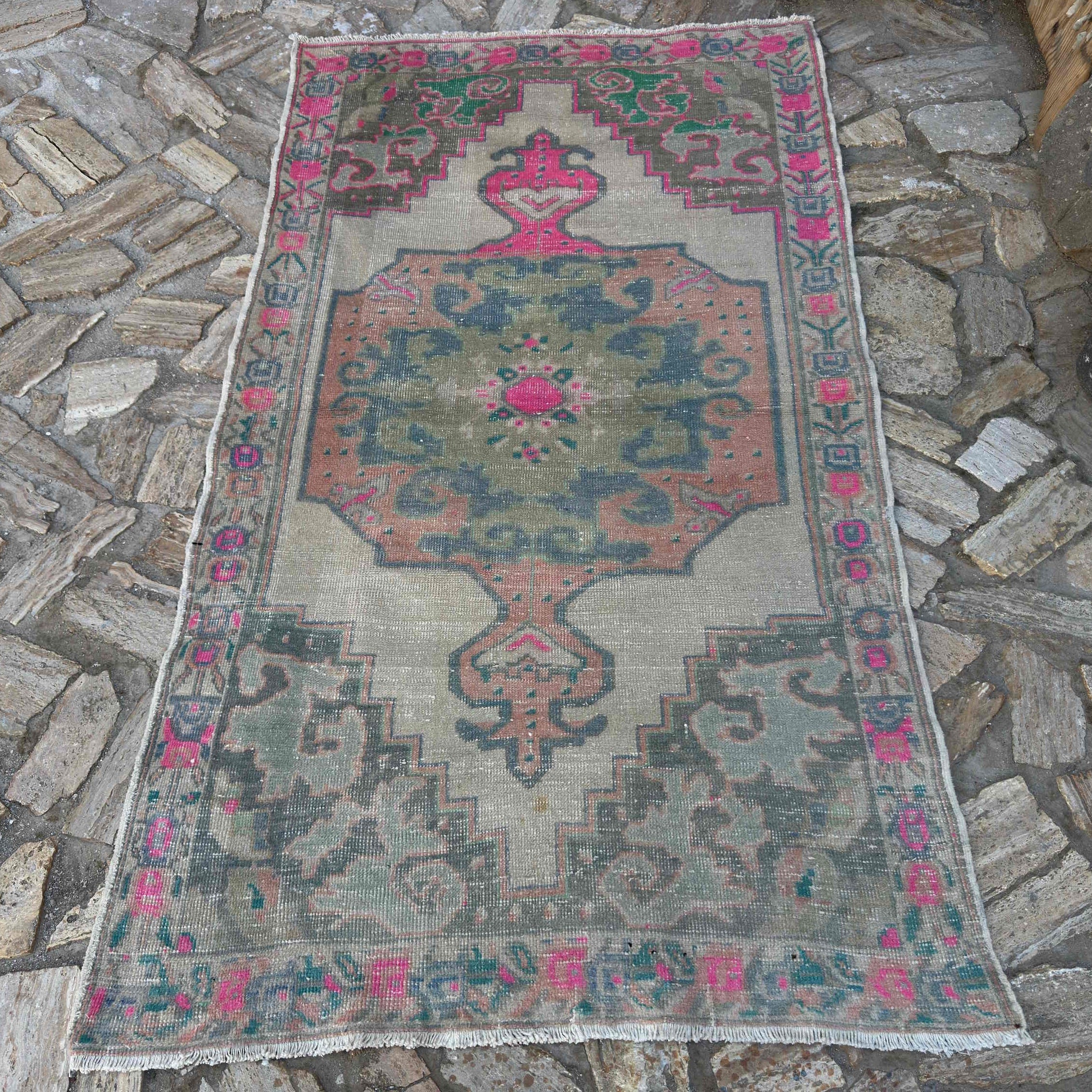 Pink 4' x 7' Turkish distressed rug in wool and cotton, shown on the floor.