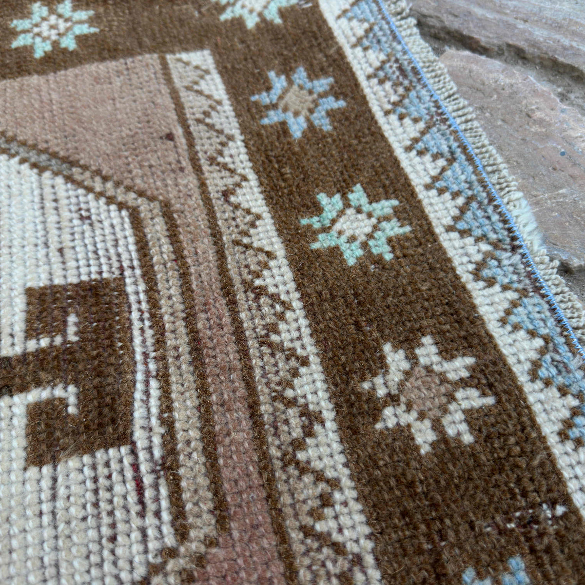 Close-up of the brown Turkish distressed runner rug showing oushak details, hand-knotted weave, wool and cotton and low pile.