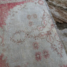 Close-up of the pale red Turkish distressed runner rug showing traditional details, hand-knotted weave, wool and cotton and low pile.