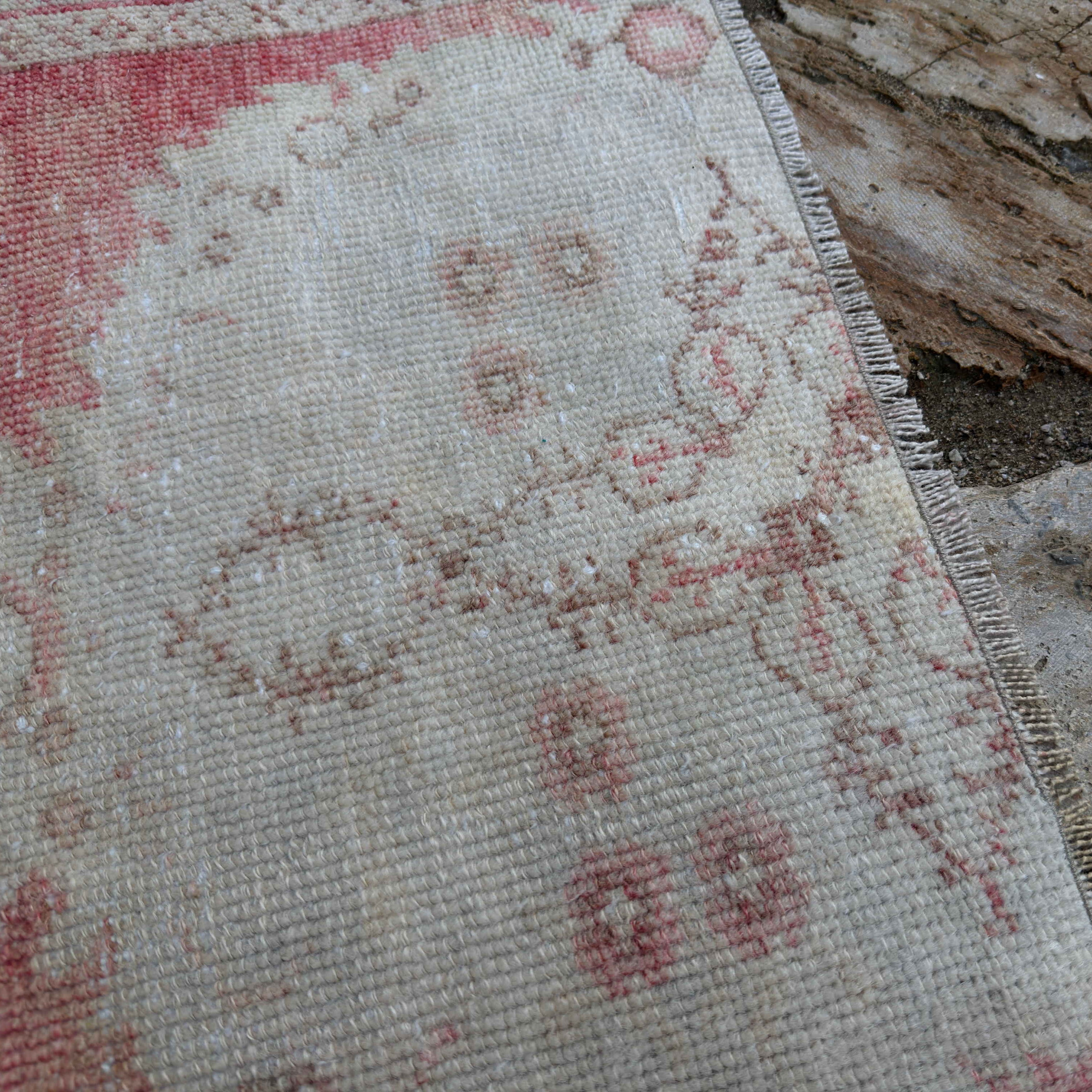 Close-up of the pale red Turkish distressed runner rug showing traditional details, hand-knotted weave, wool and cotton and low pile.