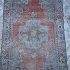 Close-up of the red distressed turkish rug showing traditional details, hand-knotted weave, wool and cotton and low pile.