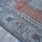 Red 3' x 5' distressed turkish rug in wool and cotton, shown on the floor.