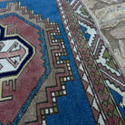 Close-up of the blue distressed turkish rug showing medallion details, hand-knotted weave, wool and cotton and low pile.
