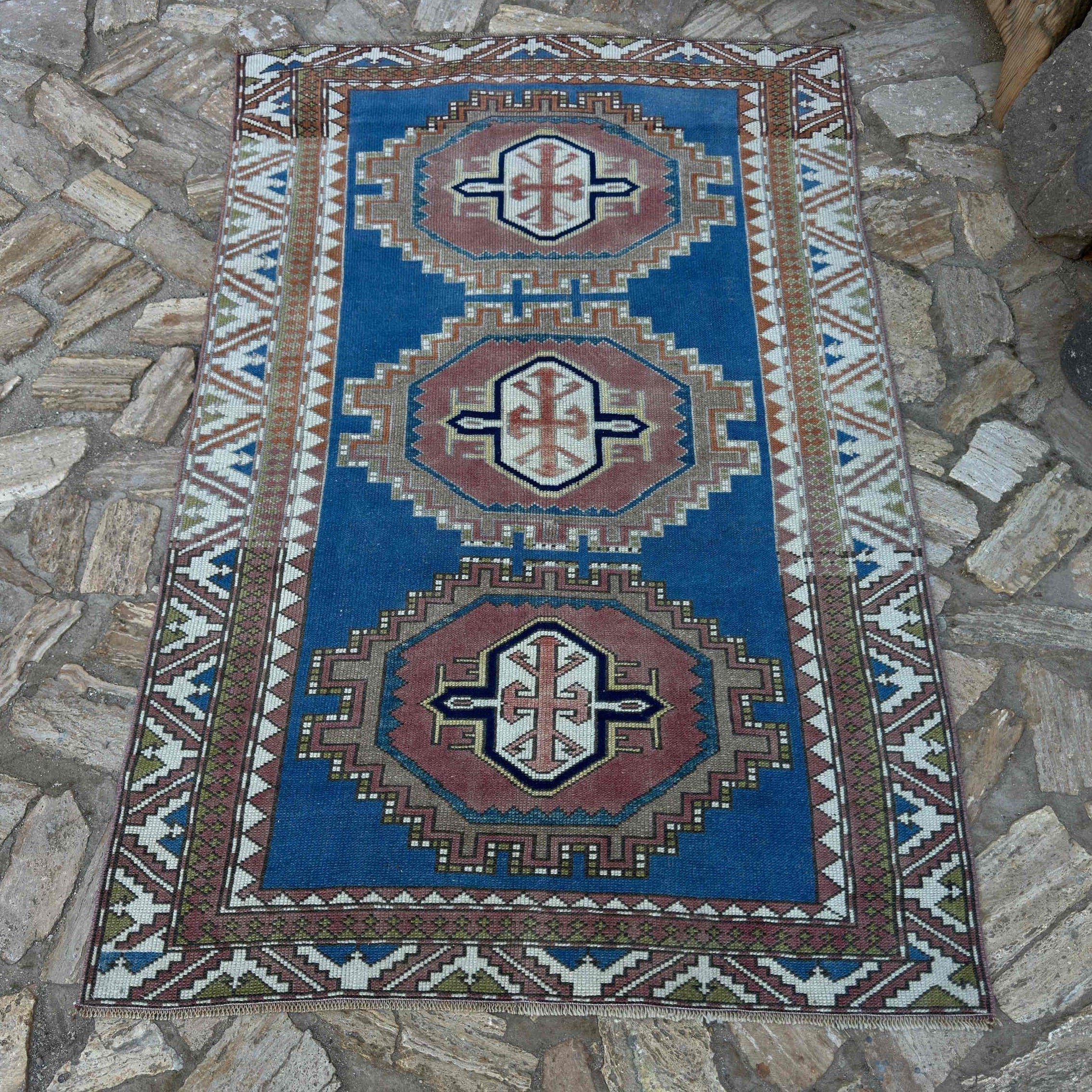 Blue 4' x 6' distressed turkish rug in wool and cotton, shown on the floor.