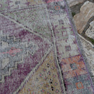 Close-up of the pale purple Turkish distressed vintage rug showing traditional details, hand-knotted weave, wool and cotton and low pile.