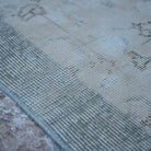 Beige 4' x 6' Turkish distressed vintage rug in wool and cotton, shown on the floor.