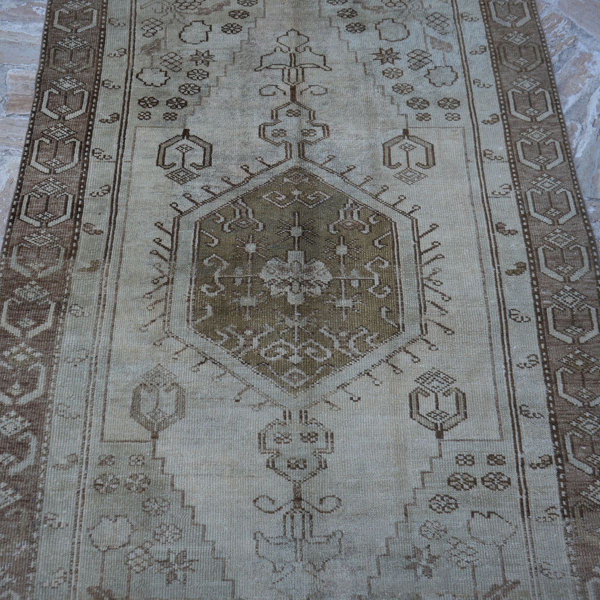 Close-up of the brown Turkish distressed vintage rug showing traditional details, hand-knotted weave, wool and low pile.