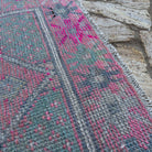 Close-up of the pink Turkish distressed vintage runner showing traditional details, hand-knotted weave, wool and cotton and low pile.