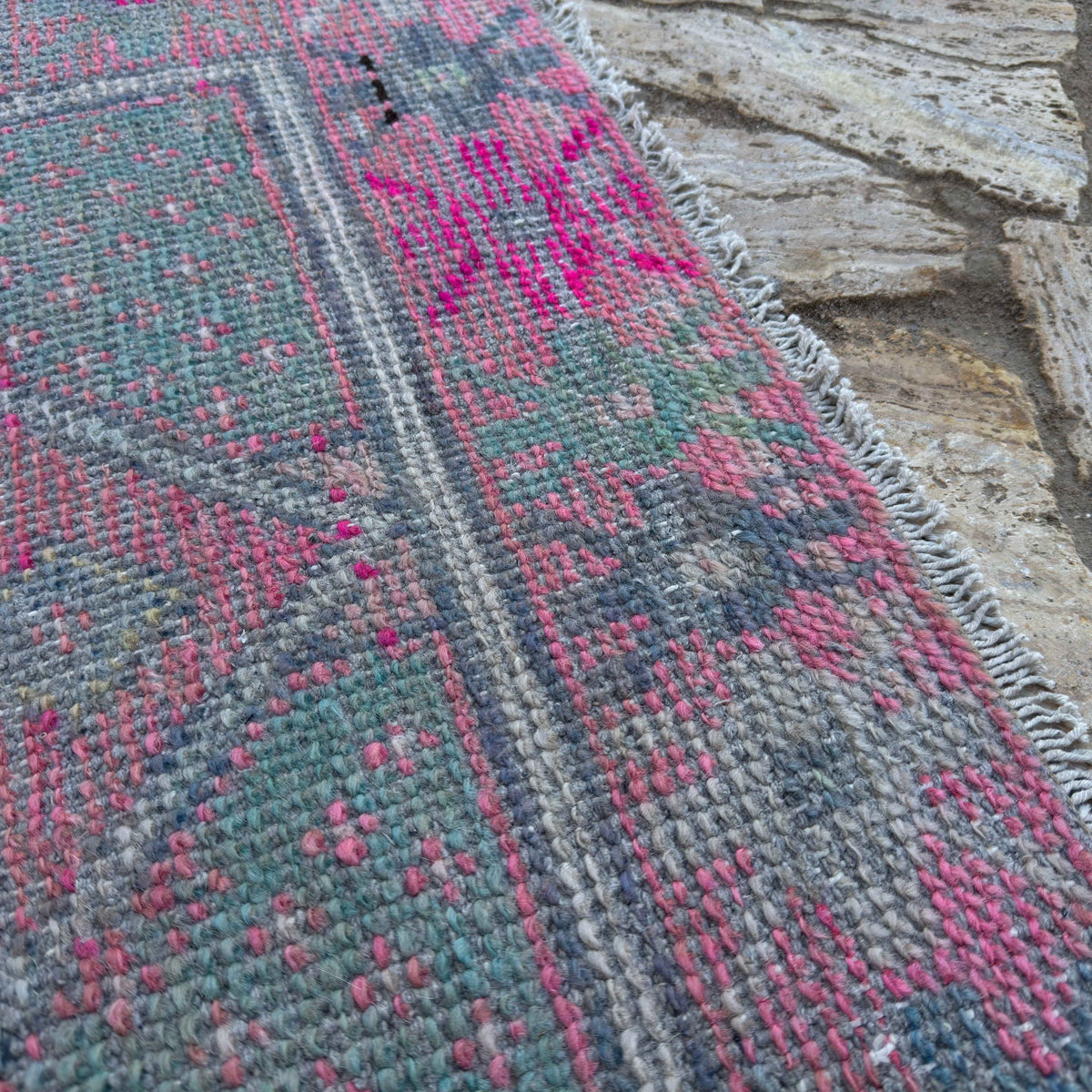 Close-up of the pink Turkish distressed vintage runner showing traditional details, hand-knotted weave, wool and cotton and low pile.