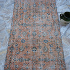 Close-up of the orange Turkish floral runner rug showing floral details, hand-knotted weave, wool and cotton and low pile.