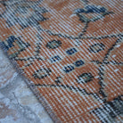 Orange 3' x 11' Turkish floral runner rug in wool and cotton, shown on the floor.