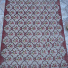 Close-up of the red floral turkish rug showing floral details, hand-knotted weave, wool and cotton and low pile.