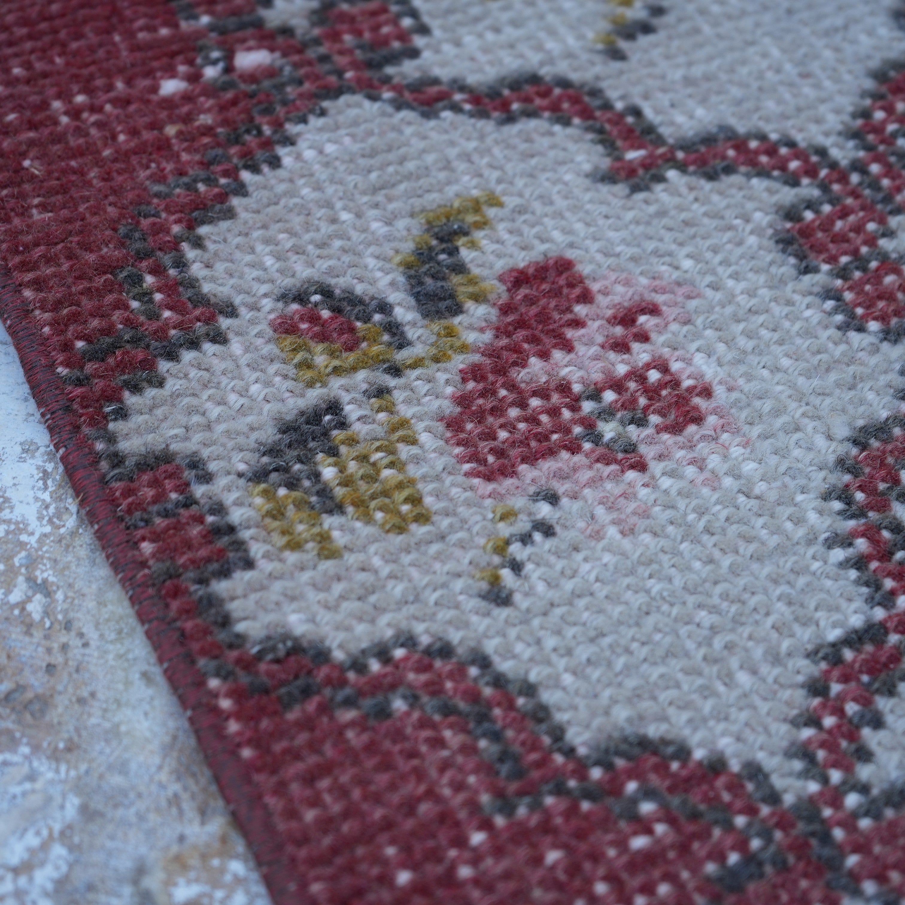Red 4' x 7' floral turkish rug in wool and cotton, shown on the floor.