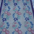 Close-up of the beige Turkish floral vintage rug showing floral details, hand-knotted weave, wool and cotton and low pile.