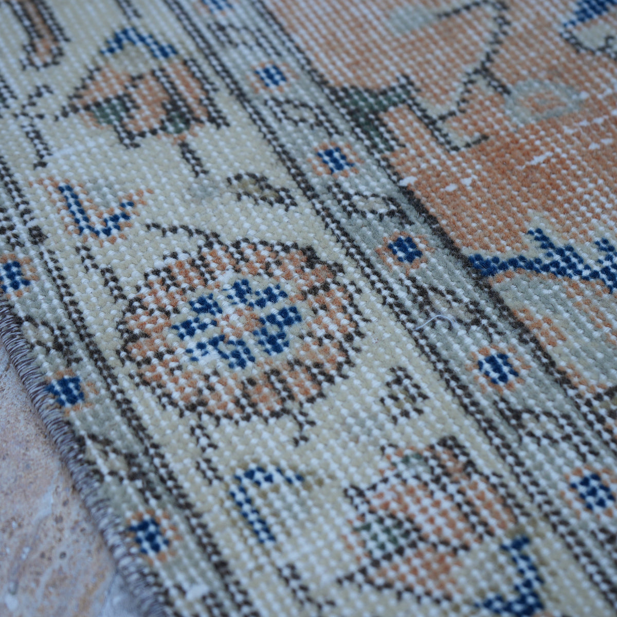 Orange 4' x 7' Turkish floral vintage rug in wool and cotton, shown on the floor.