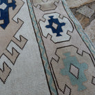 Close-up of the pale pink Turkish geometric area carpet showing neutral details, hand-knotted weave, wool and cotton and low pile.