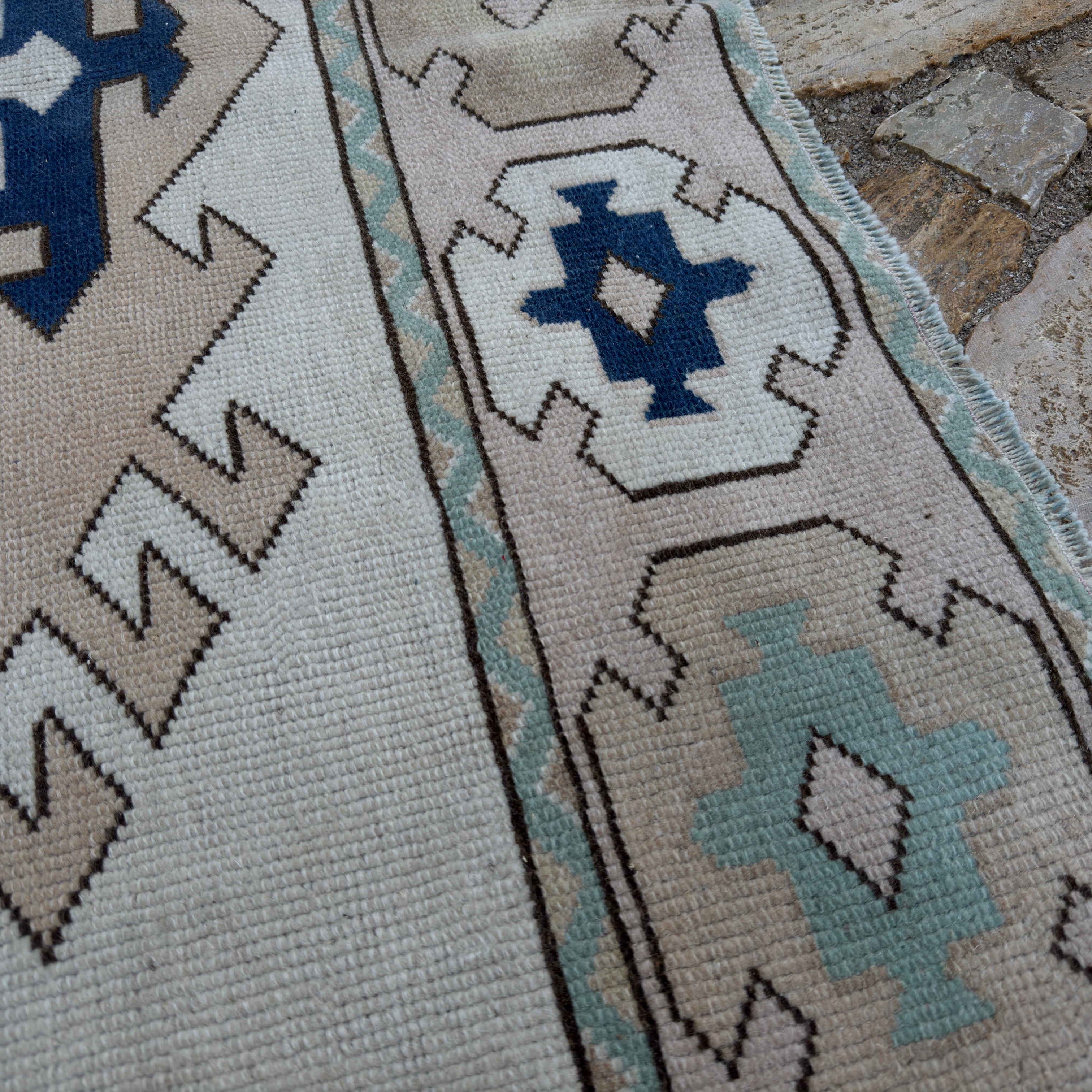 Close-up of the pale pink Turkish geometric area carpet showing neutral details, hand-knotted weave, wool and cotton and low pile.