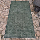 Green 4' x 7' geometric turkish rug in wool and cotton, shown on the floor.
