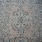 Close-up of the pink hand-knotted persian rug showing medallion details, hand-knotted weave, wool and cotton and low pile.