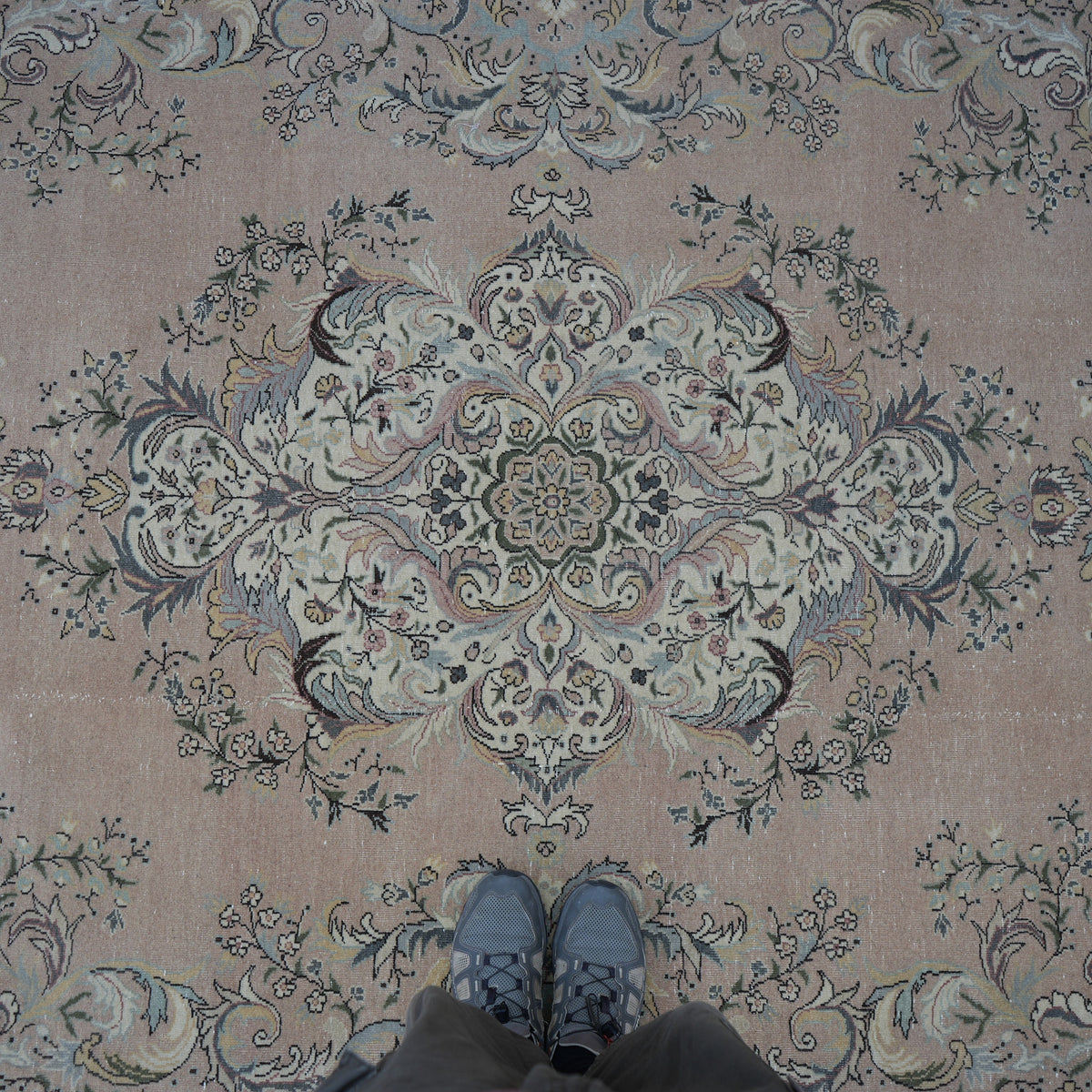 Pink 8' x 12' hand-knotted persian rug in wool and cotton, shown on the floor.
