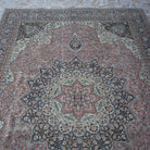 Close-up of the pink hand-knotted persian rug showing medallion details, hand-knotted weave, wool and cotton and low pile.