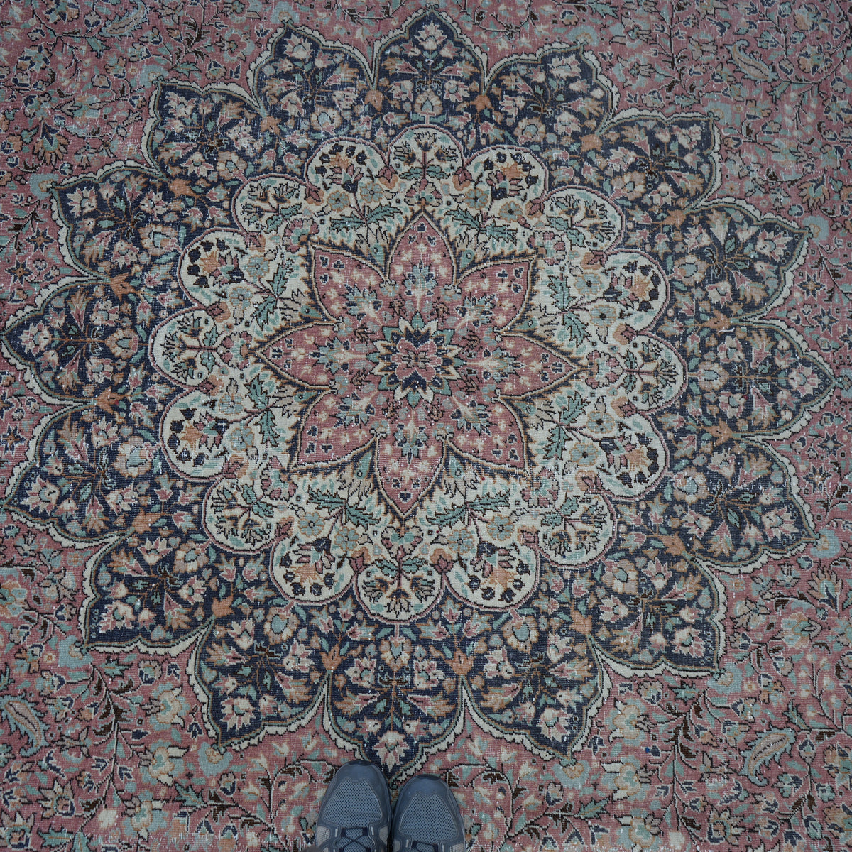 Pink 8' x 13' hand-knotted persian rug in wool and cotton, shown on the floor.