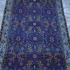 Close-up of the purple Turkish handknotted floral rug showing floral details, hand-knotted weave, wool and cotton and low pile.