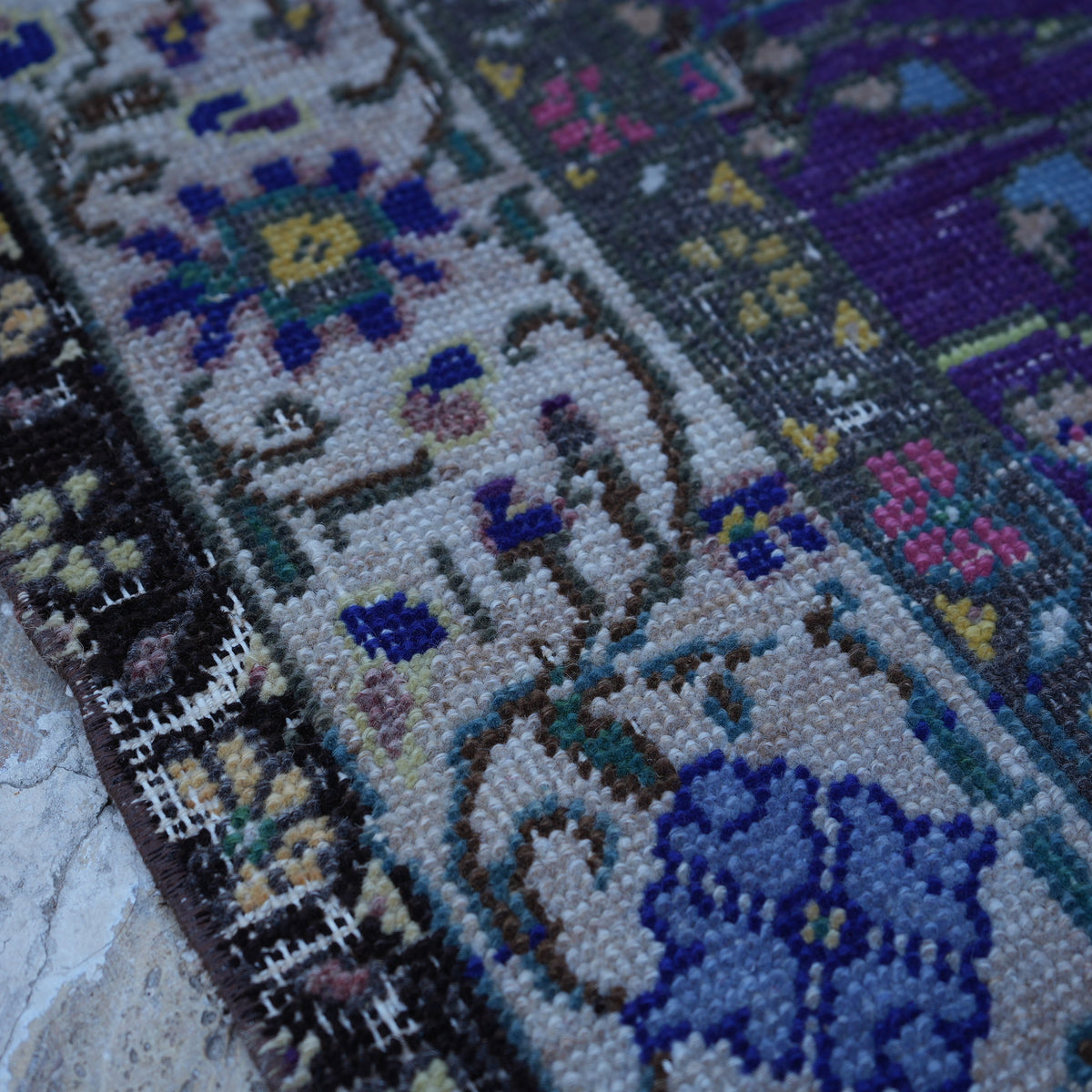 Purple 5' x 8' Turkish handknotted floral rug in wool and cotton, shown on the floor.