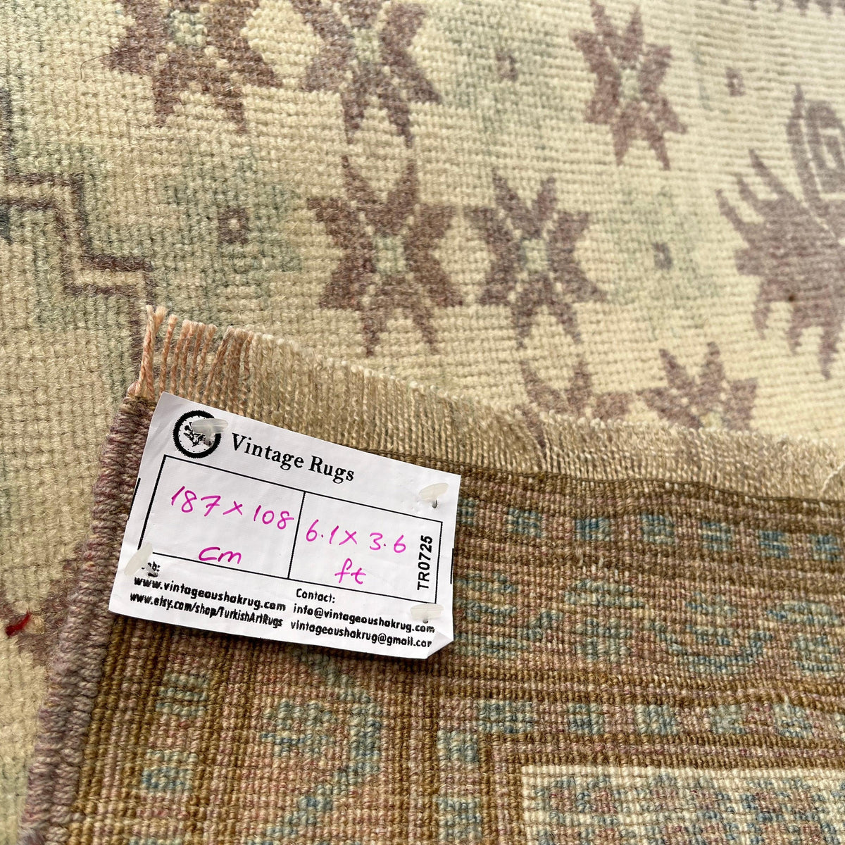 Close-up of the pink Turkish handknotted rug showing traditional details, hand-knotted weave, wool and cotton and low pile.