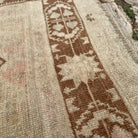 Close-up of the brown Turkish handknotted rug showing traditional details, hand-knotted weave, wool and cotton and low pile.