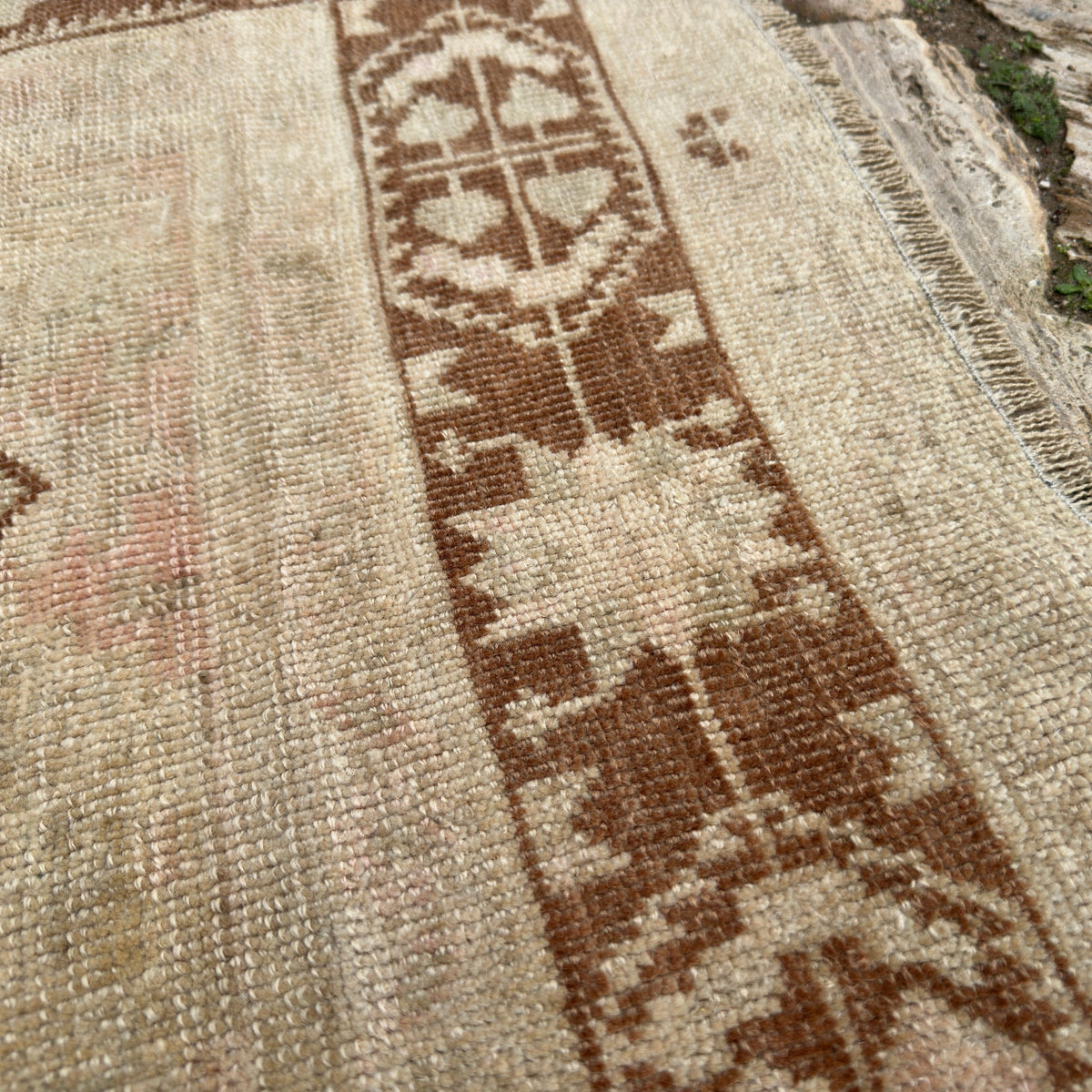 Close-up of the brown Turkish handknotted rug showing traditional details, hand-knotted weave, wool and cotton and low pile.