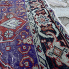 Close-up of the purple Turkish handknotted rug showing geometric details, hand-knotted weave, wool and cotton and low pile.