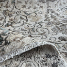 Close-up of the green Turkish handknotted rug showing neutral details, hand-knotted weave, wool and cotton and low pile.